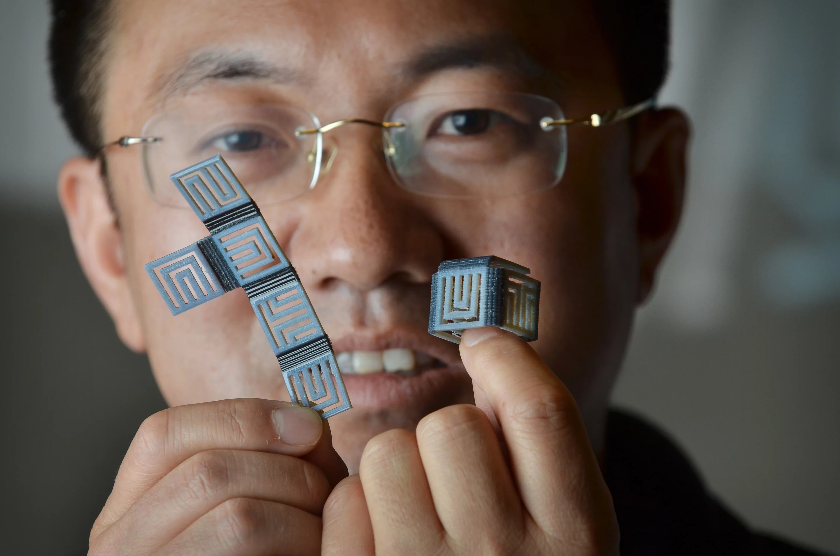 Prof. H. Jerry Qi with identical 4D-printed objects in their flat and folded states