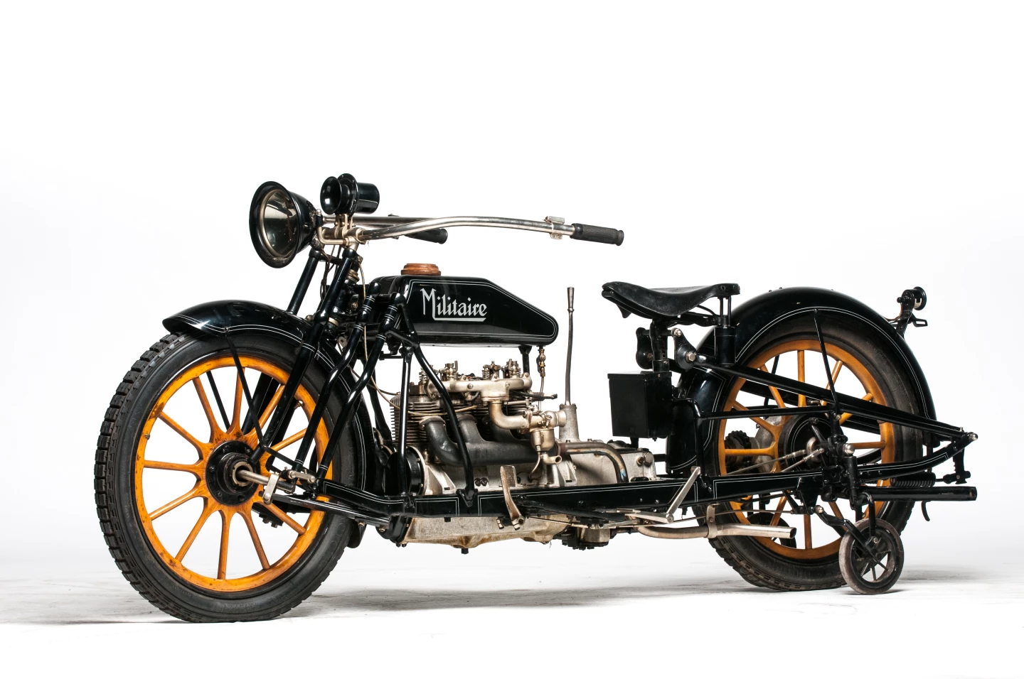This 1915 Militaire Model 2 is a fascinating and unconventional four-cylinder motorcycle with an equally fascinating history as it was developed through several manufacturers. Now very collectible and extremely rare, the "two-wheeled car" features outrigger wheels which are operated by lever for low speeds, center-hub steering and wooden wheels.
