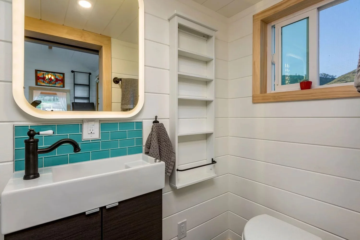 The Joshua Tree tiny house's bathroom includes a shower, sink, and a composting toilet