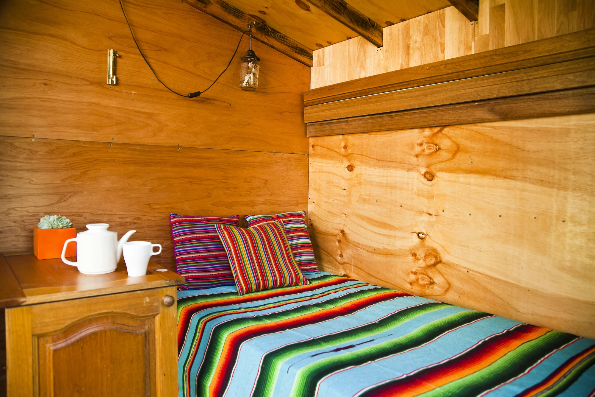 Inside The Tiny, there's a fold-up bed, storage crates which double-up as seating, and folding shelves and a folding desk (Photo: Alicia Fox Photography)