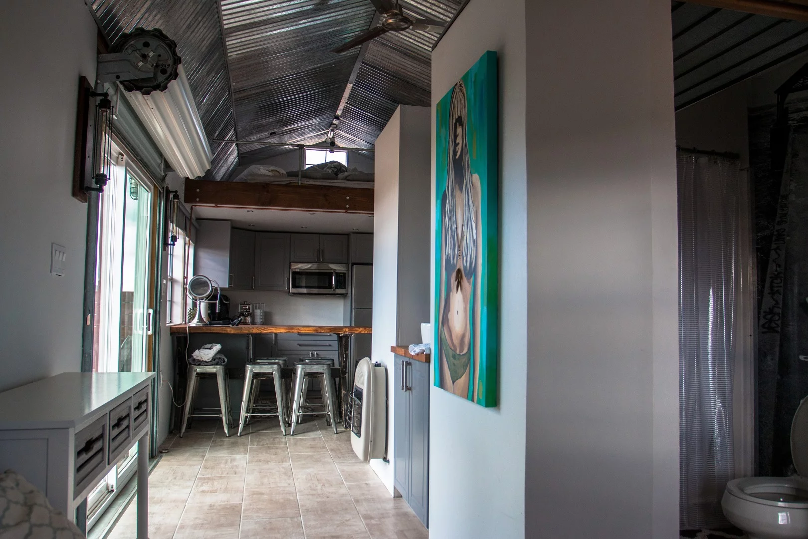 The bathroom is set right next to the living room. He plumbed the entire interior with exposed copper piping, which adds to the modern look and feel inside.