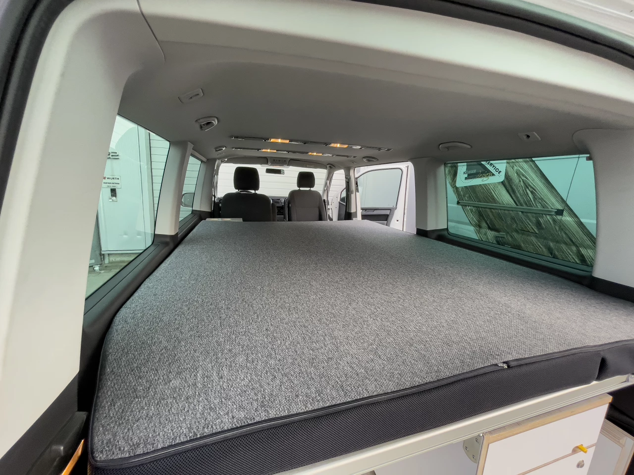 The Good Life bed folds down to cover the rest of the camper kit, providing more space than the average midsize van camper bed