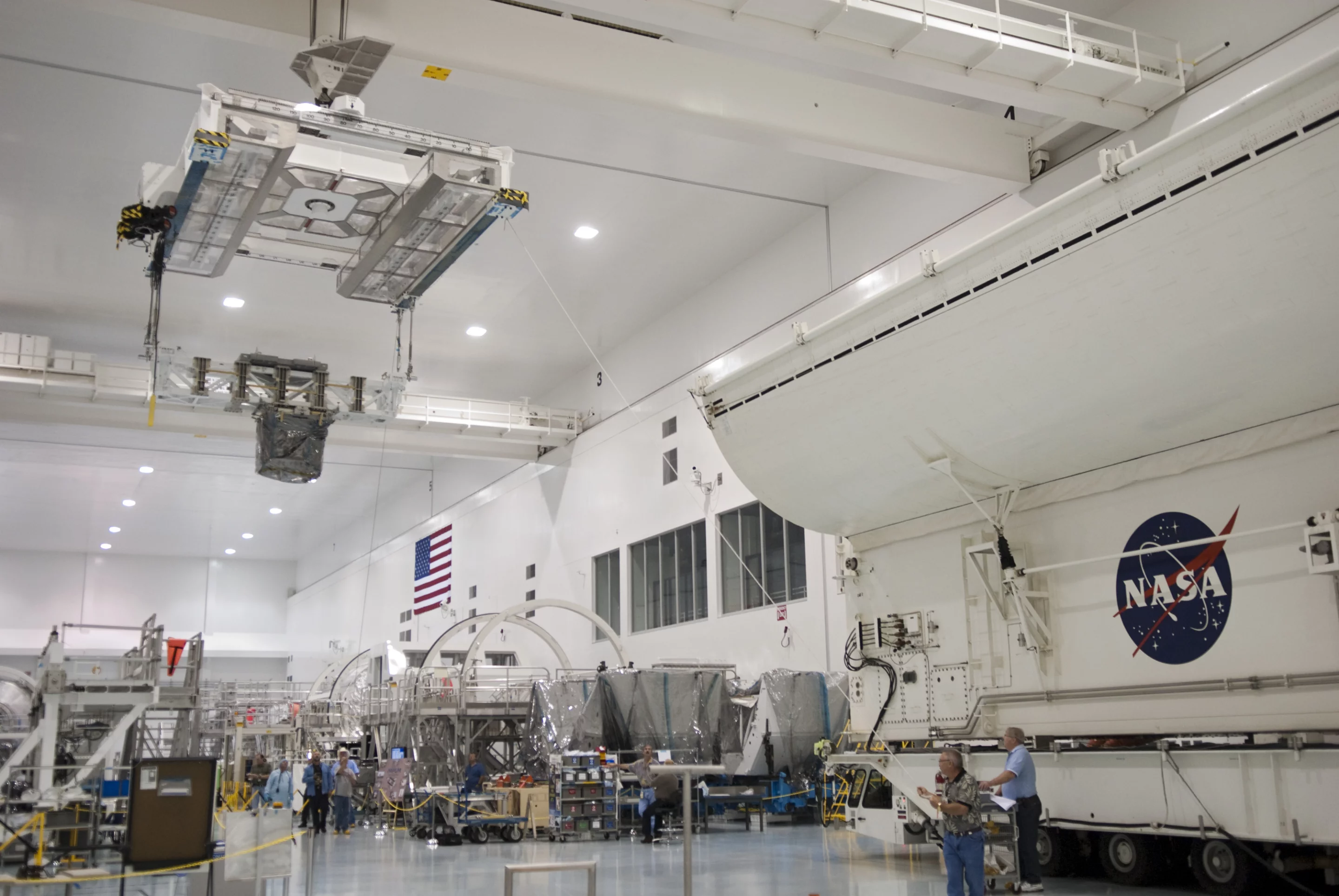 The Robotic Refueling Mission experiment (hanging from carrier, left), as it is being installed in the STS-135 shuttle payload canister at Kennedy Space Center (Image: NASA)