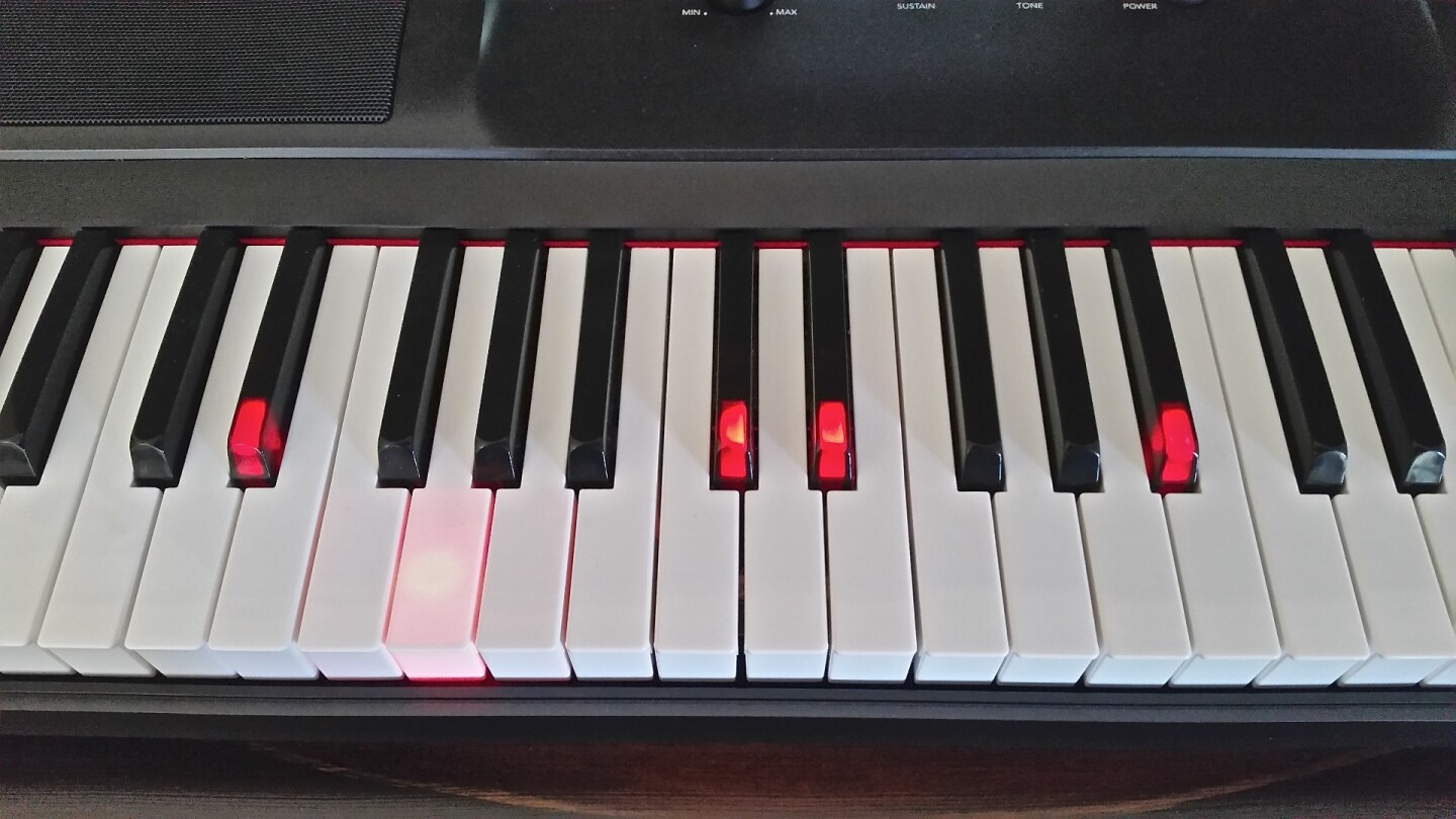 Lighted keys show where the left and right hand should be playing