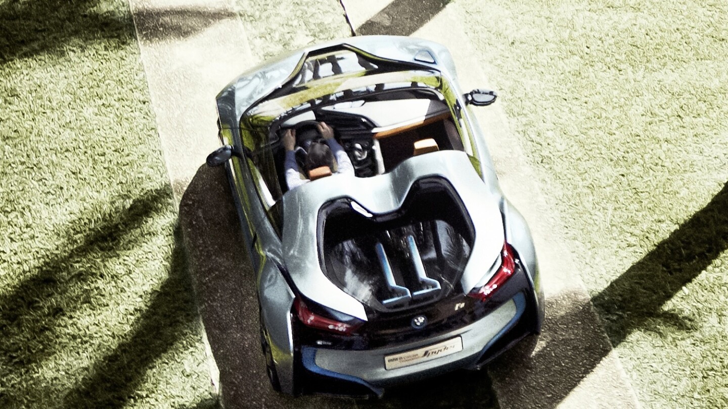 BMW's i8 Spyder with two matching BMW three-wheeled electric kick scooters in the rear