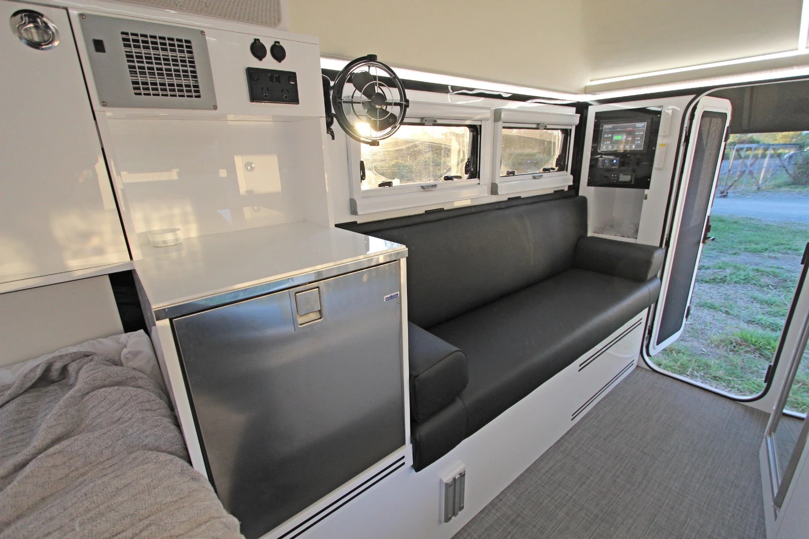 An indoor refrigerator joins the slide-out fridge in offering plenty of cold storage and completing the indoor/outdoor kitchen space