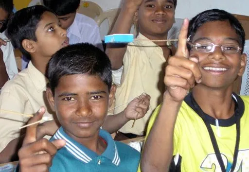Indian children playing with one of Arvind Gupta's scientific toys, that they made themselves