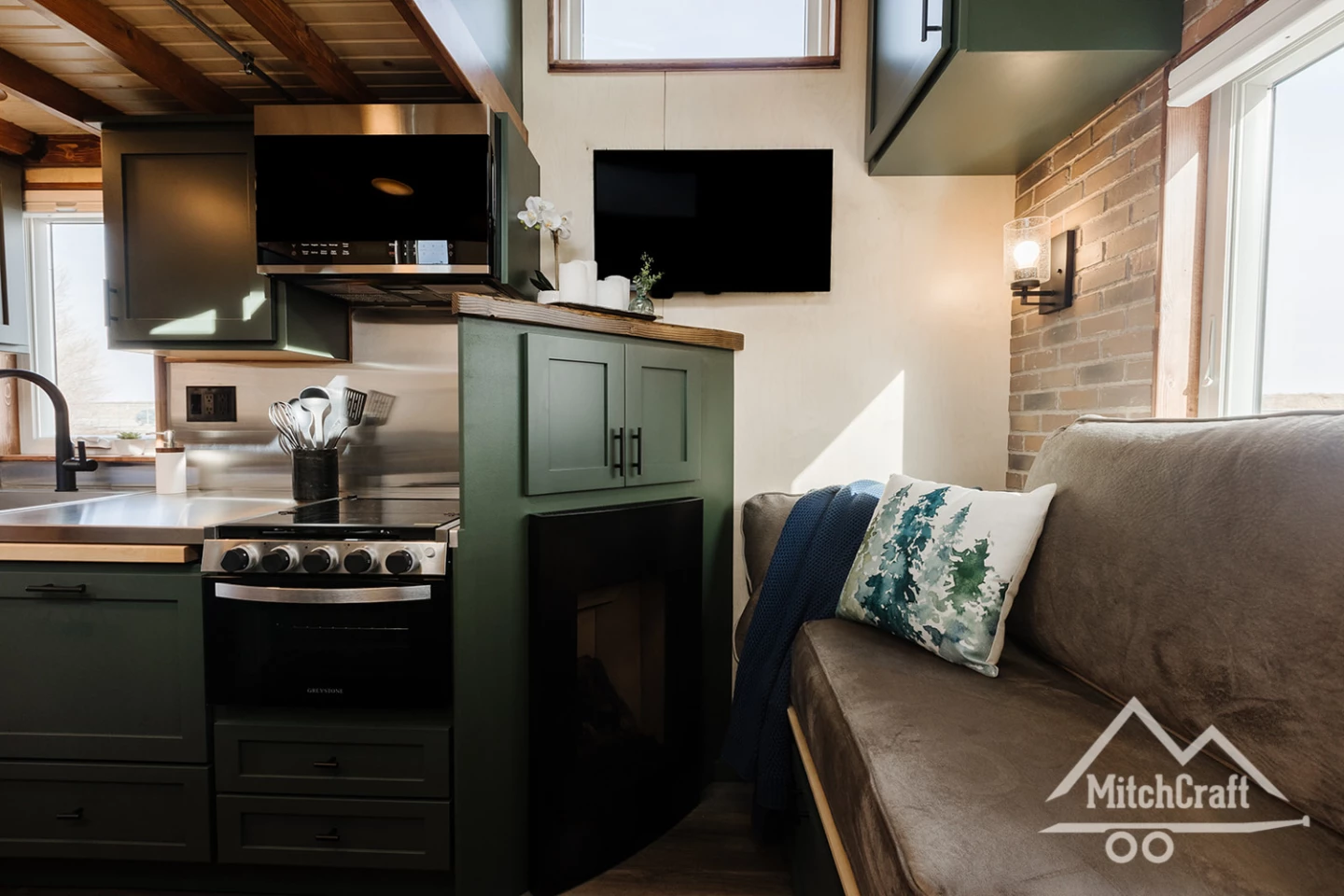 Nicole's 16 x 8 Tiny Home includes a small electric fireplace in the living room (a mini-split air-conditioning system is also installed for heating and cooling), as well as a TV mounted on the wall