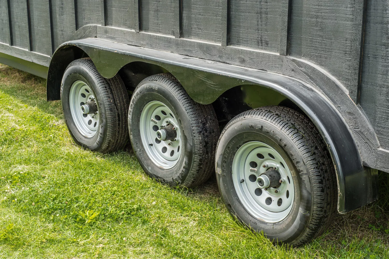 The towable home sits on a three-axle trailer