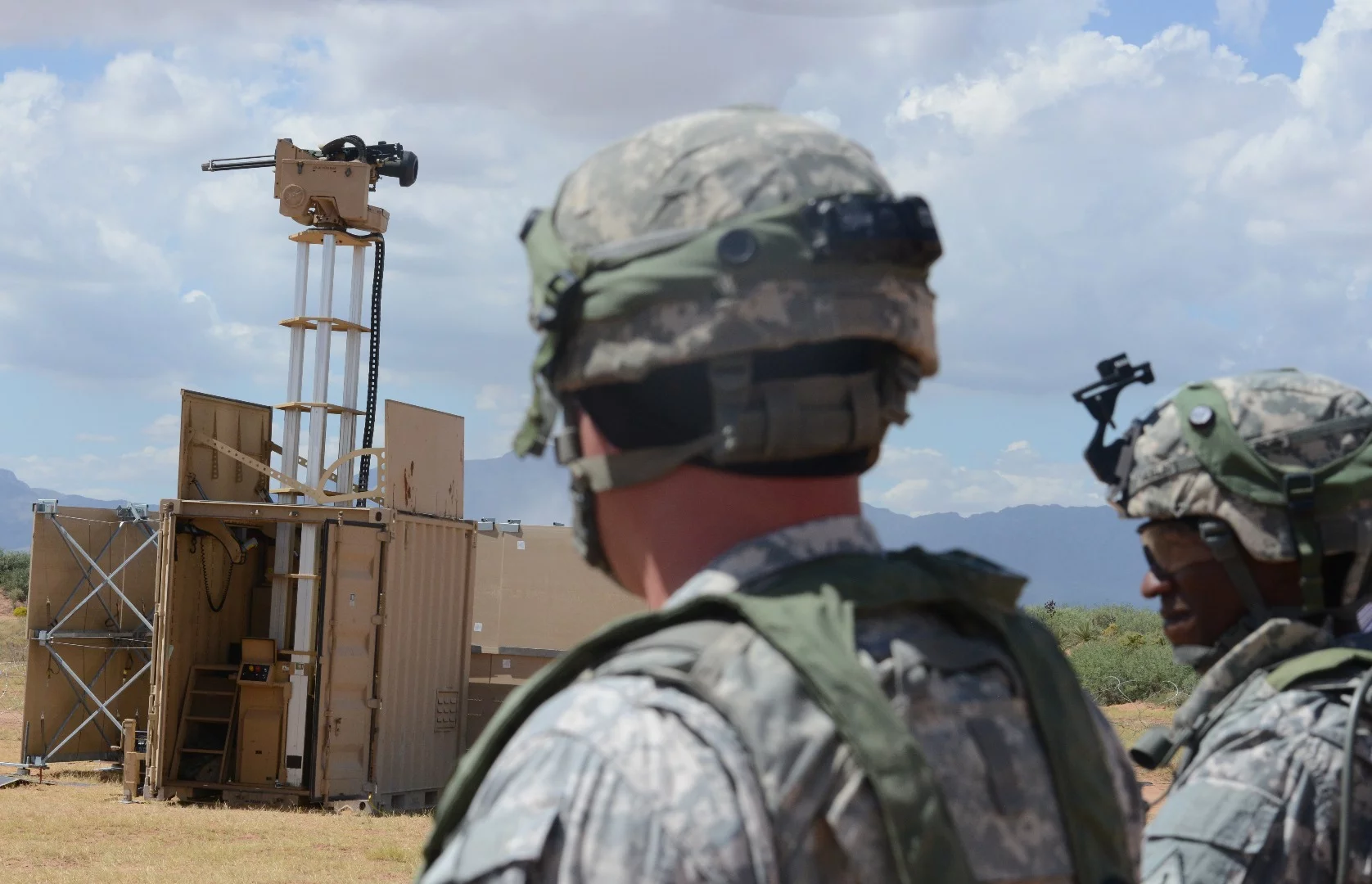 Lieutenant Colonel Raphael Heflin, right, commander, 142nd Combat Service Support Battalion, 1st Armored Division, and another soldier pass near a remotely-controlled weapons system