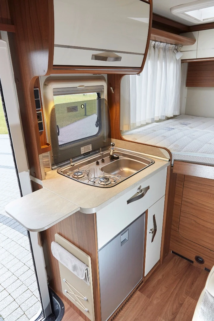 The kitchen packs a two-burner stove, sink and refrigerator