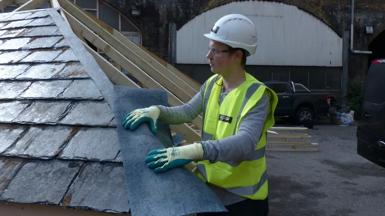 Alex Chinneck holding part of the roof (Photo: Tommophoto)