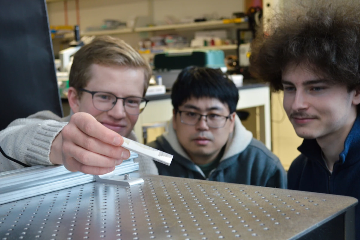 Researchers on the study hold a sample of a metamaterial designed to reflect ultrasound waves in a way that moves an object without physical contact