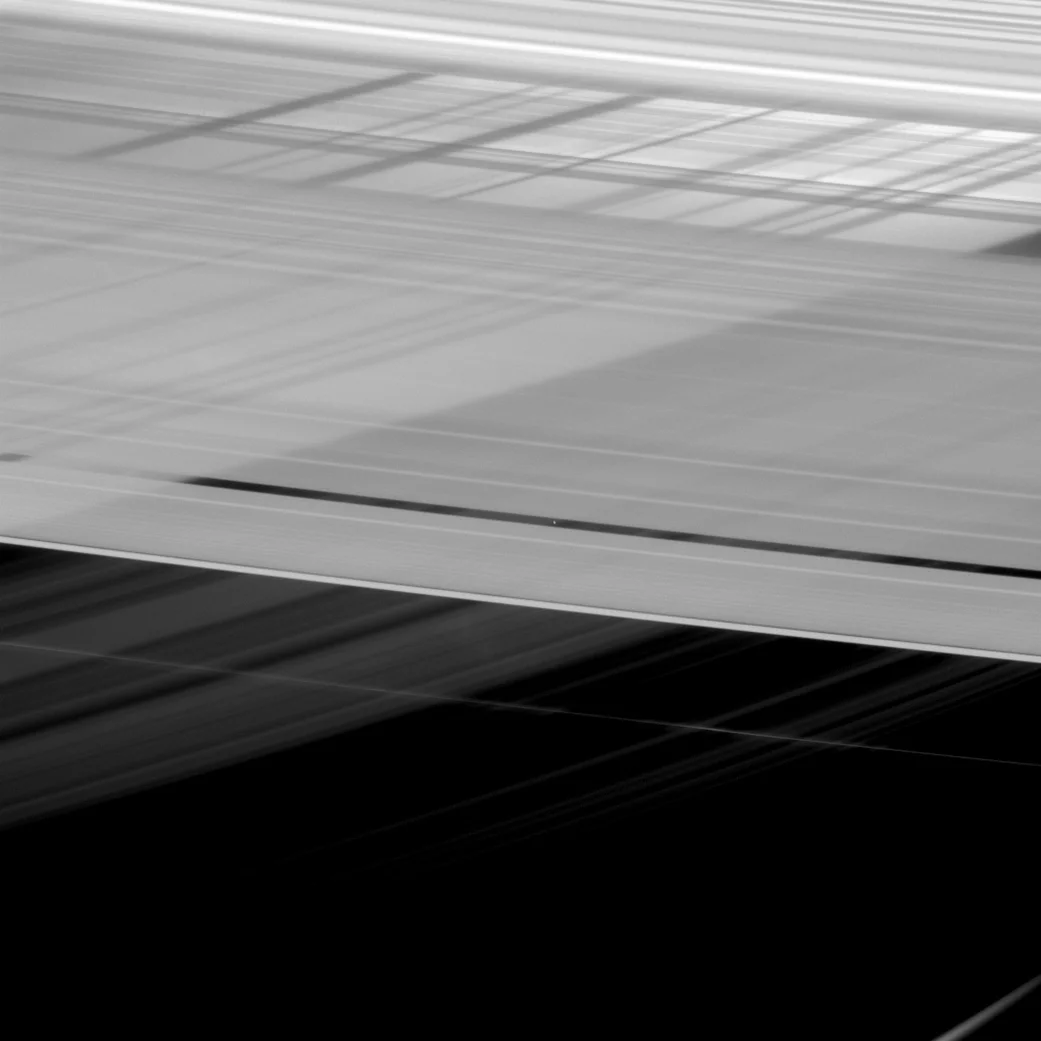 An optical illusion created by the shadow cast by Saturn's rings gives the false impression that two sets of rings are overlapping one another