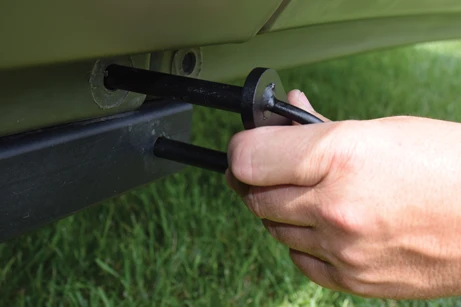 Flipping the connector bolt simultaneously detaches the front of the trailer from the frame and connects the two halves of the boat