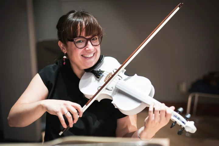 Mary-Elizabeth Brown with a full-size version of her group's 3D-printed violin
