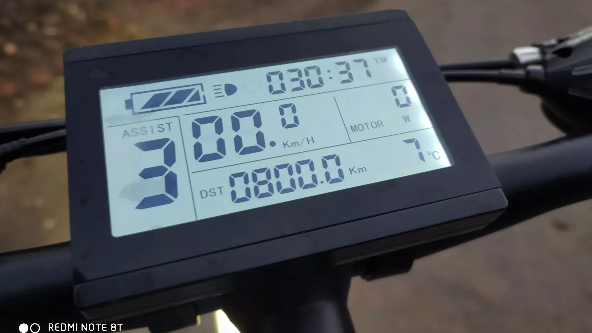 A handlebar-mounted LCD display shows ride and ebike info