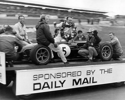 Victory lap at Brands Hatch 1967: from left to right Goodyear's European racing director Leo Mehl (from the back), Goodyear technician, Jo Ramirez, Mike Lowman, Tim Wall, Dan Gurney, "Haff" Haffenden, Bill Dunne, Goodyear technician.