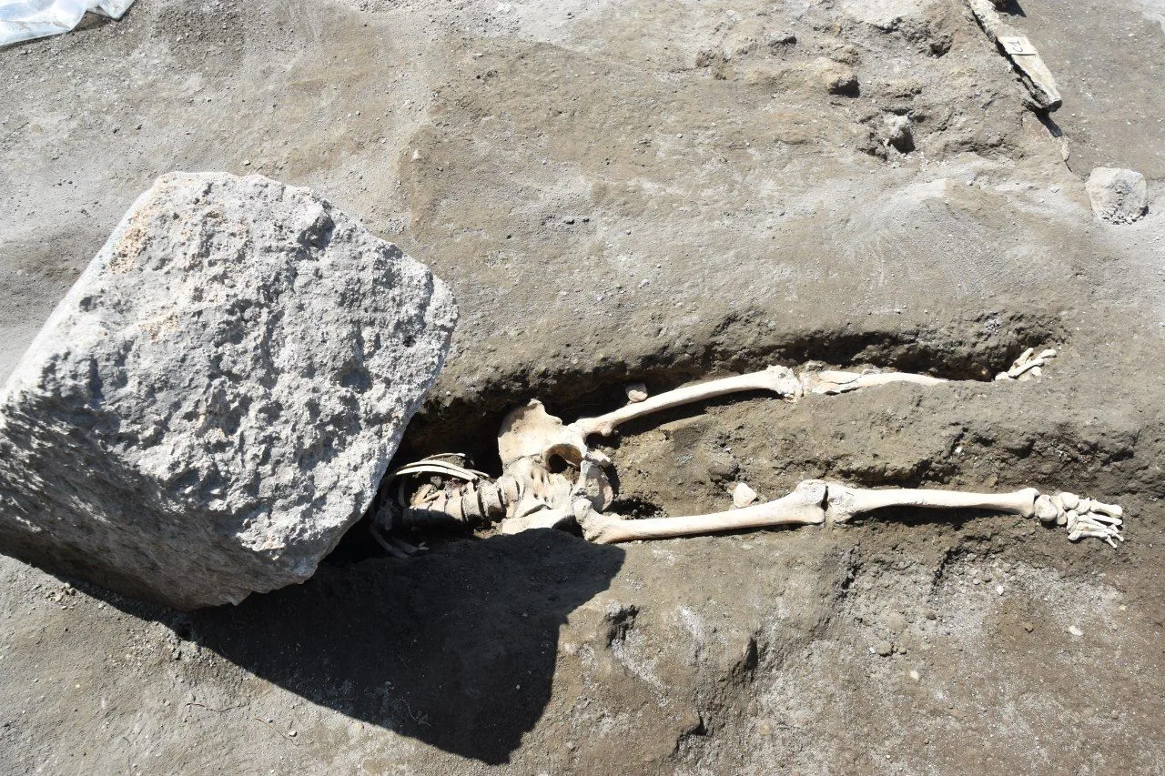 Archaeologists have uncovered the 2,000-year-old skeleton of a man crushed beneath a huge stone block, while trying to flee the volcanic eruption that wiped out Pompeii