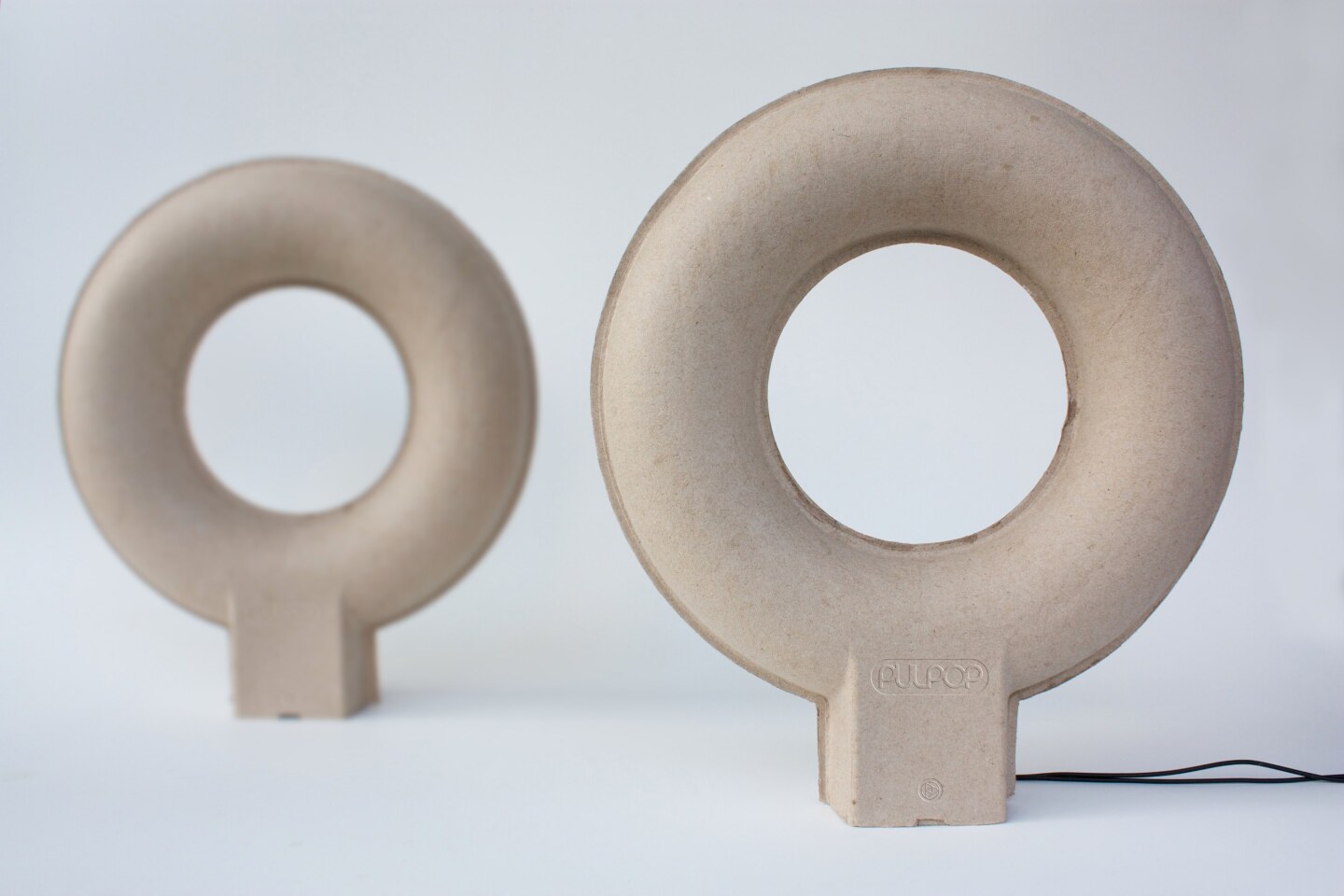 As sound doesn't usually travel well through paper, the hollow loop doughnut shape is said to provide enough surface area to distribute sound more evenly
