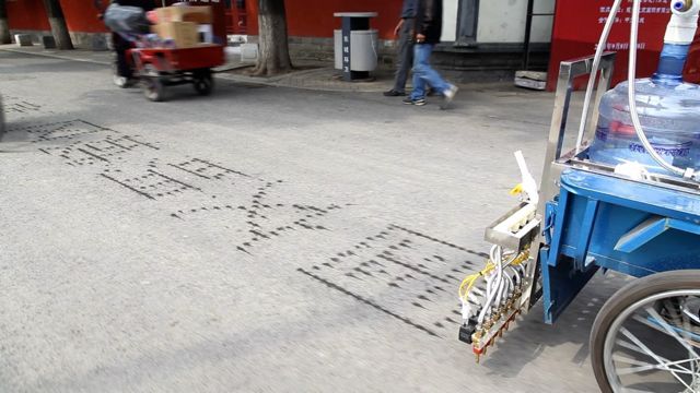 Hanna's trike in the process of laying down its water calligraphy