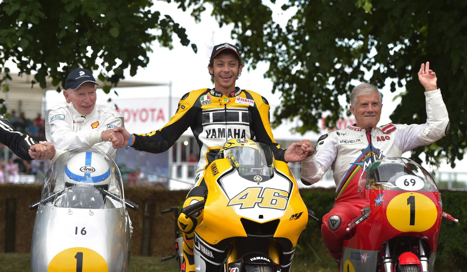 John Surtees, Valentino Rossi and Giacomo Agostini in the Goodwood Paddock
