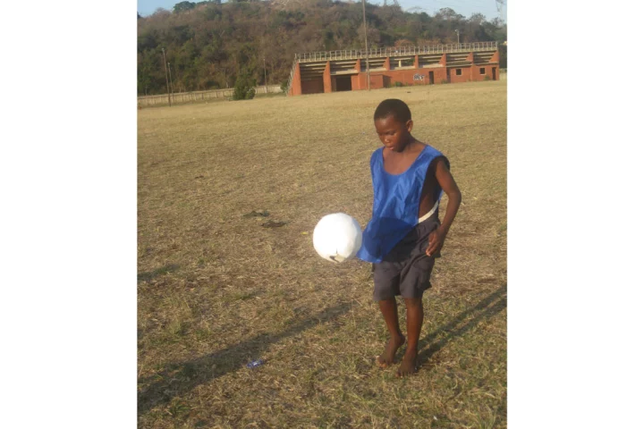 A young lad tests out the prototype sOccket power-generating soccer ball in a Durban, South Africa, trial of the device
