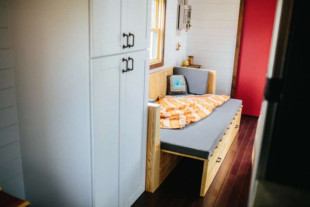 The couch has integrated storage space and pulls out to serve as a guest bed