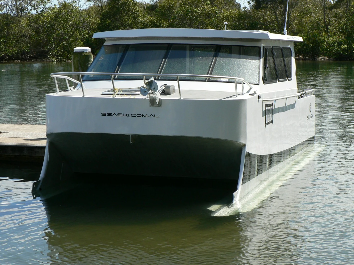 The 7-m (23-ft) vessel with its skis submerged at slow speed or moored at Fingal Boat Harbour, Northern New South Wales, Australia – it has a very wide beam at 3 m (9.8 ft)