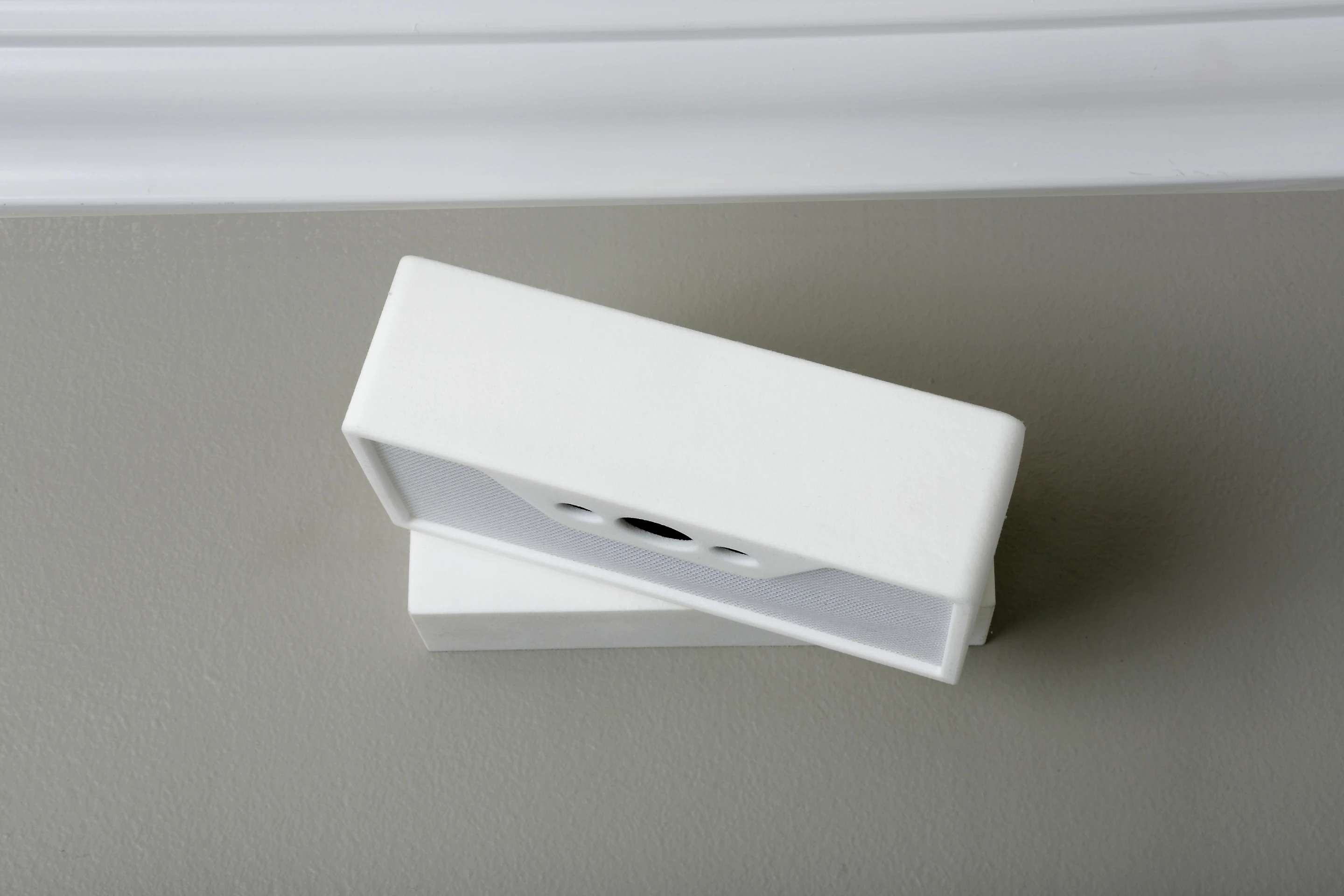 The white-brick-shaped box is attached to a wall mount above the user's bed (Photo: Lucera Labs)