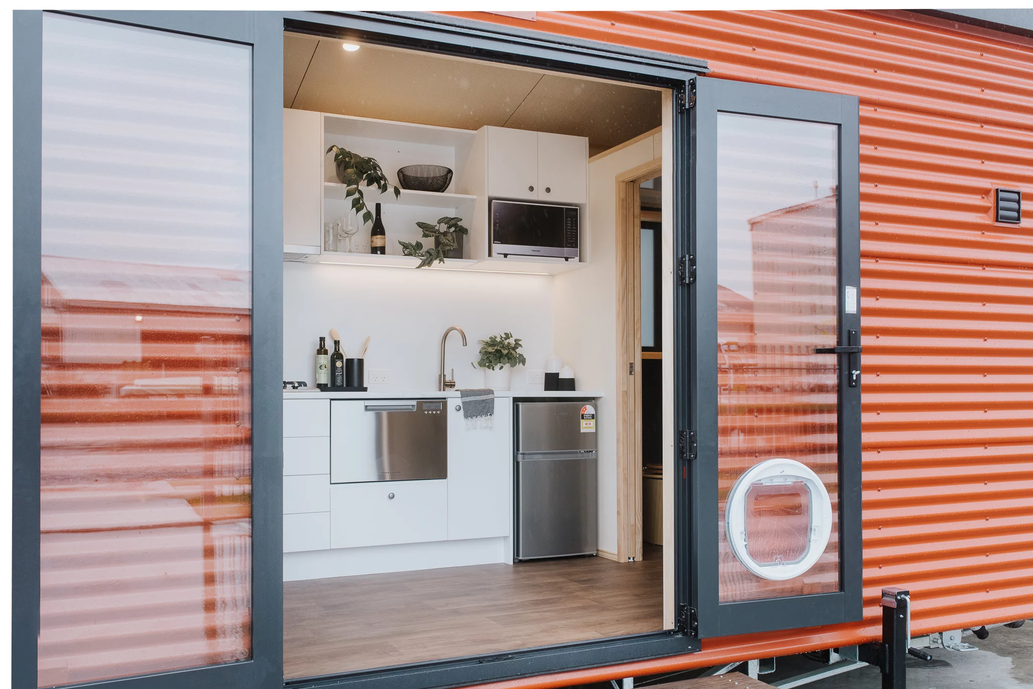 The Te Whare Nukunuku Tiny House is accessed by double glass doors that really open up the home to the outside