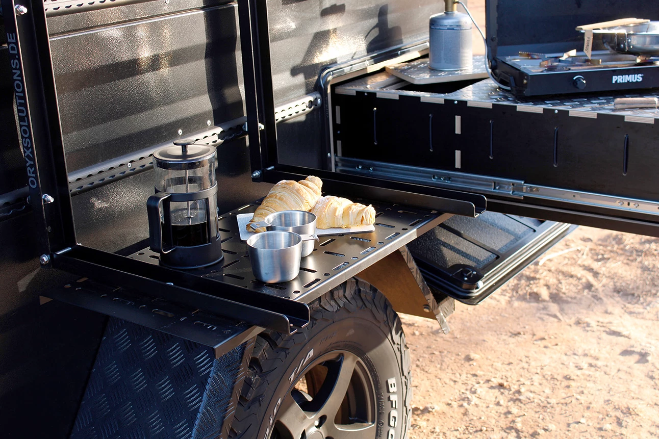 A drop-down side table mounted to the tie-down track creates a coffee and pastry station