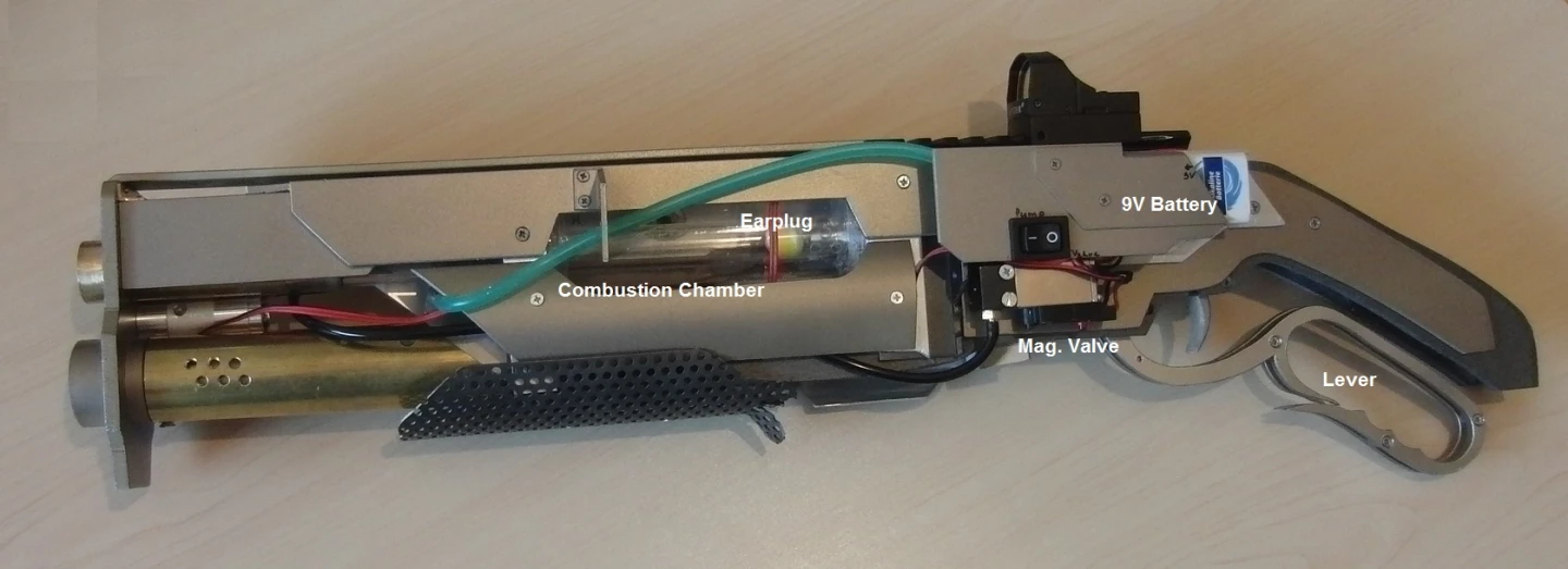 Squeezing the trigger part way causes lighter fluid gas to flow from the lighter into the transparent Plexiglass combustion chamber, while switching on the gun's air pump delivers air into that chamber