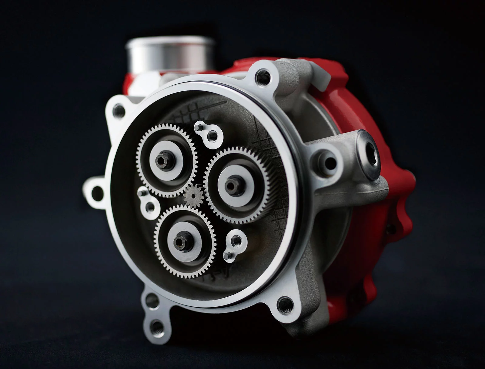 The supercharger is driven by a planetary gear train, which runs off the crankshaft. Designing the gear train using technology from Kawasaki’s Aerospace Company resulted in a very compact unit, with minimal power loss. The gear train increases the impeller speed to 9.2x the crank speed (via a 1.15x step gear and 8x planetary gear). This means that at maximum engine speed (approximately 14,000 min-1), the impeller shaft is spinning at almost 130,000 min-1. Mounted in a thrust bearing structure, the impeller shaft floats on a film of oil.