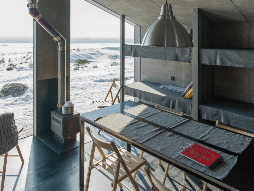 The cabin is warmed with a wood-burning stove