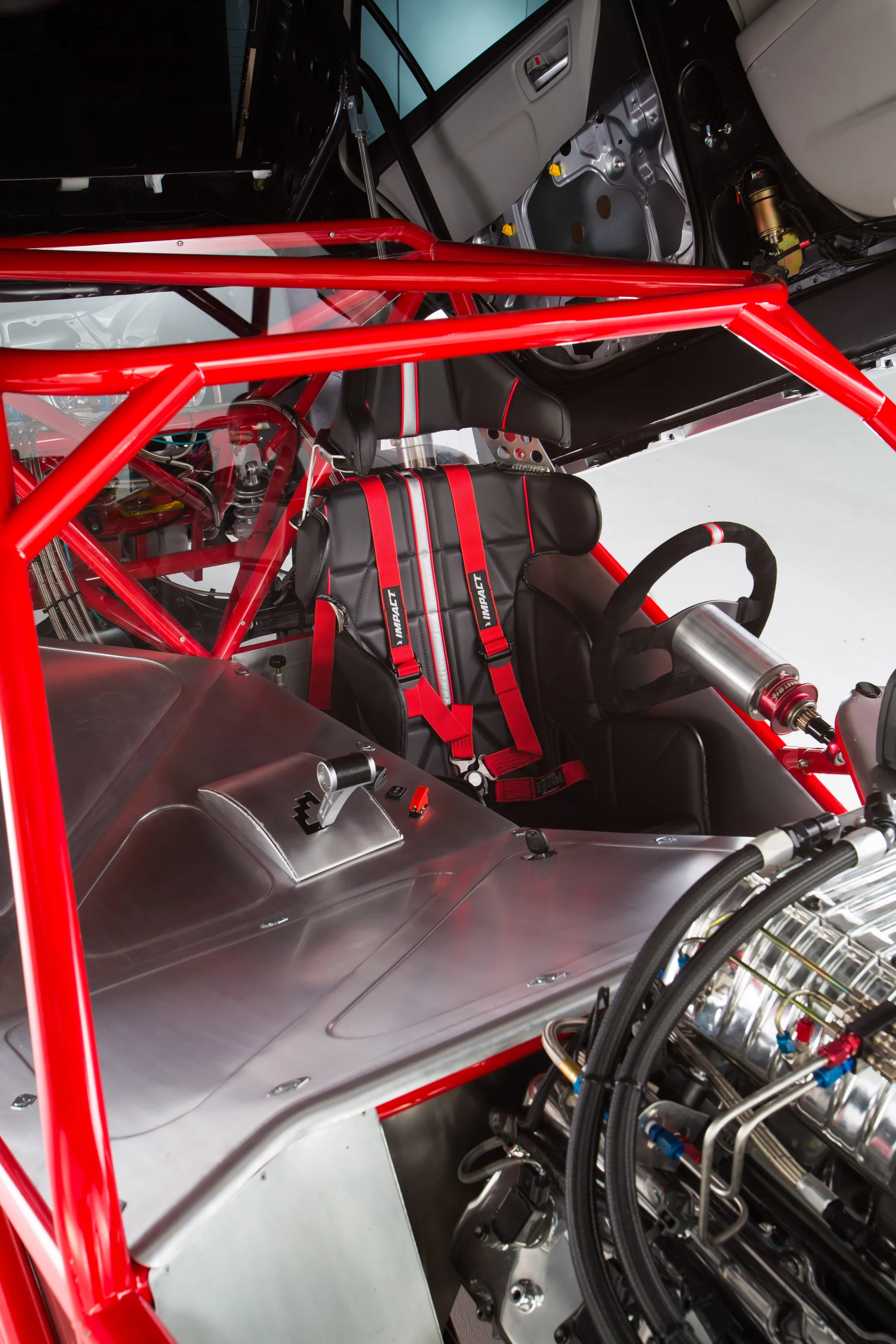 The driver is secured with an Impact Racing safety harness