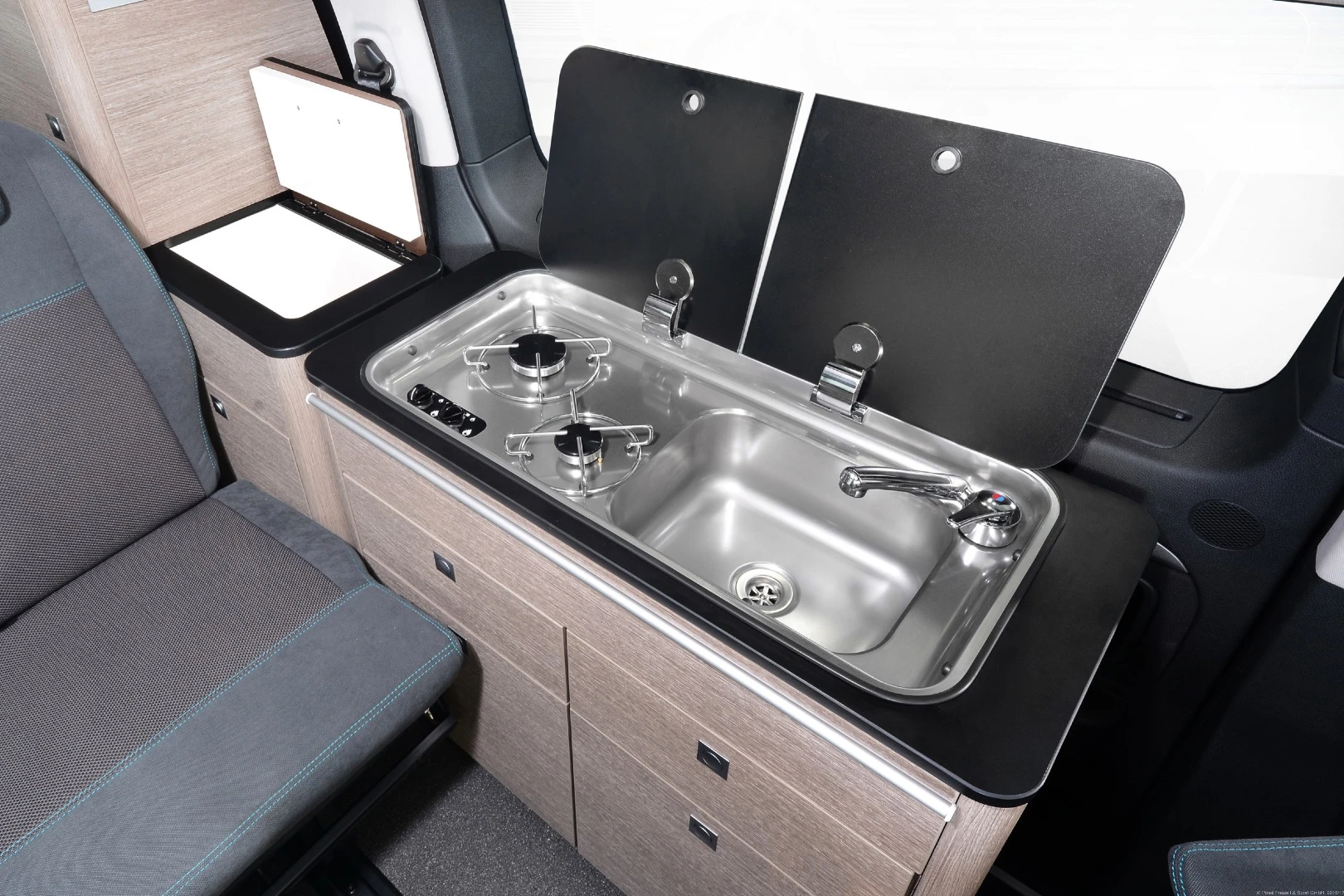 The Pössl Campster kitchen includes a two-burner stove and sink