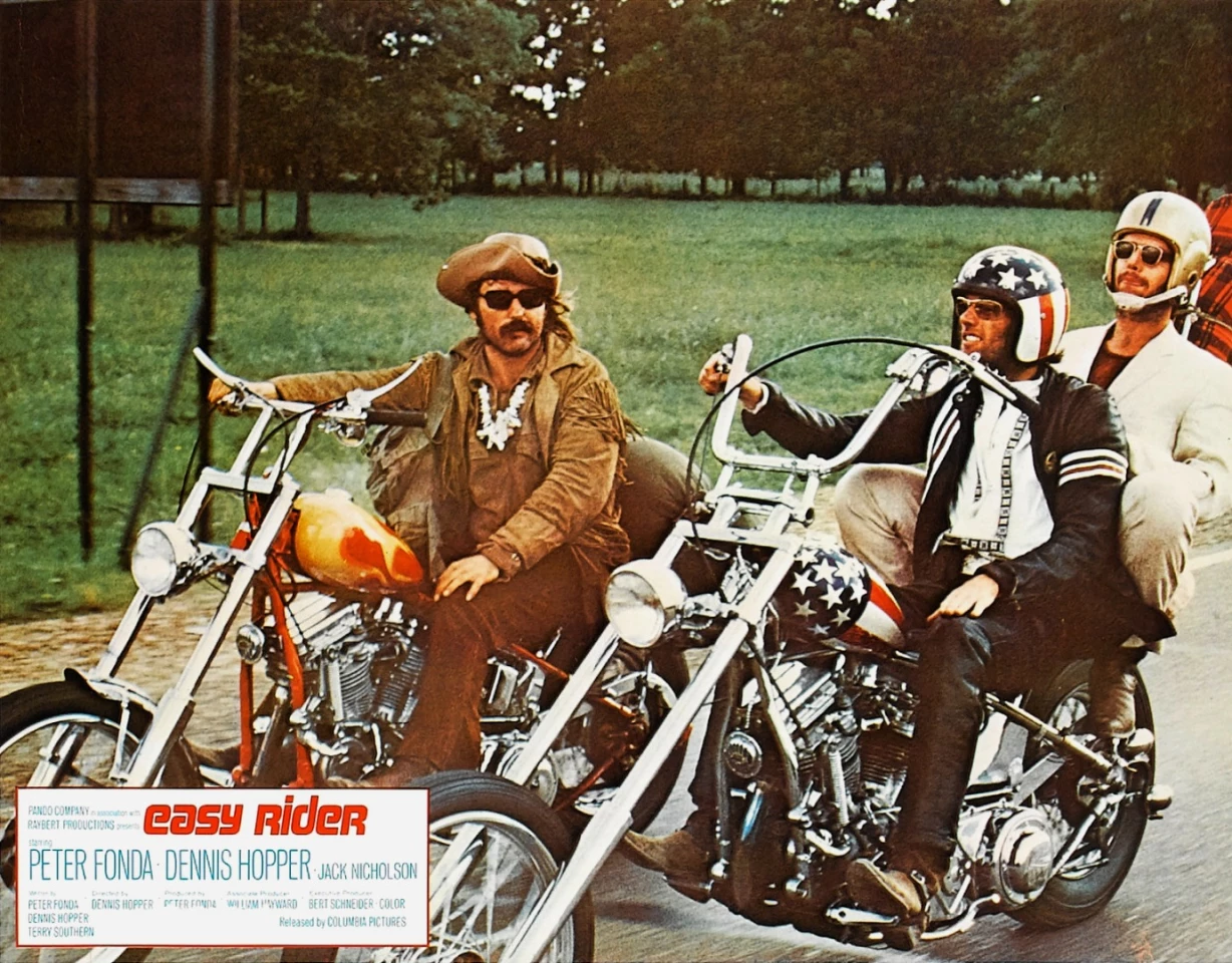 The Captain America bike is perhaps the most famous and best known motorcycle in movie history, seen here with Peter Fonda riding two-up with Jack Nicholson on pillion in the movie Easy Rider.
