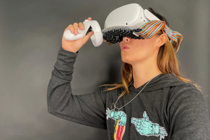 Using the mouth haptics system, Vivian Shen feels the sensation of liquid on her lips as she takes a virtual drink