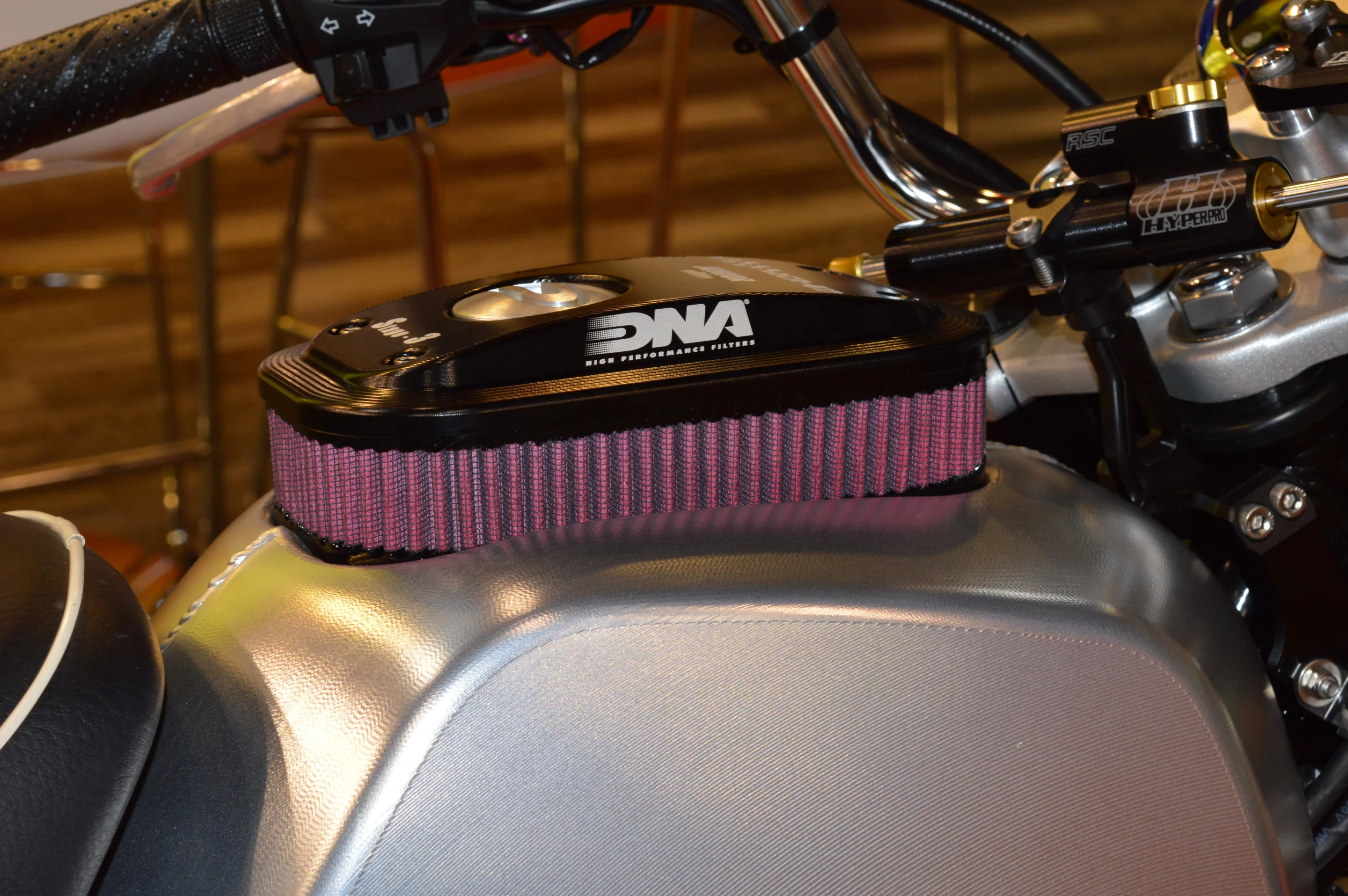 Air filter specialists DNA revealed this unique kit for Honda Monkey 125, consisting of a billet aluminum fuel tank with the air filter element integrated on the top and housing the fuel cap. It draws inspiration from the DCR017 custom KTM that DNA had unveiled at the 2017 EICMA