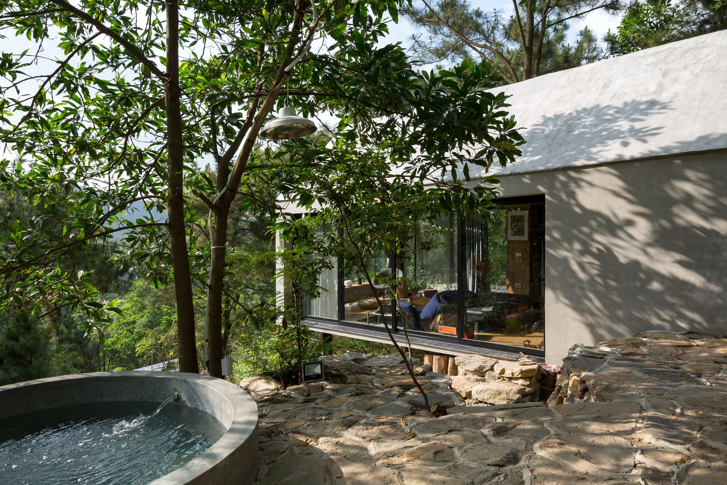 A double glass sliding door connects the kitchen area to the outdoor landscape which leads to an outdoor tub