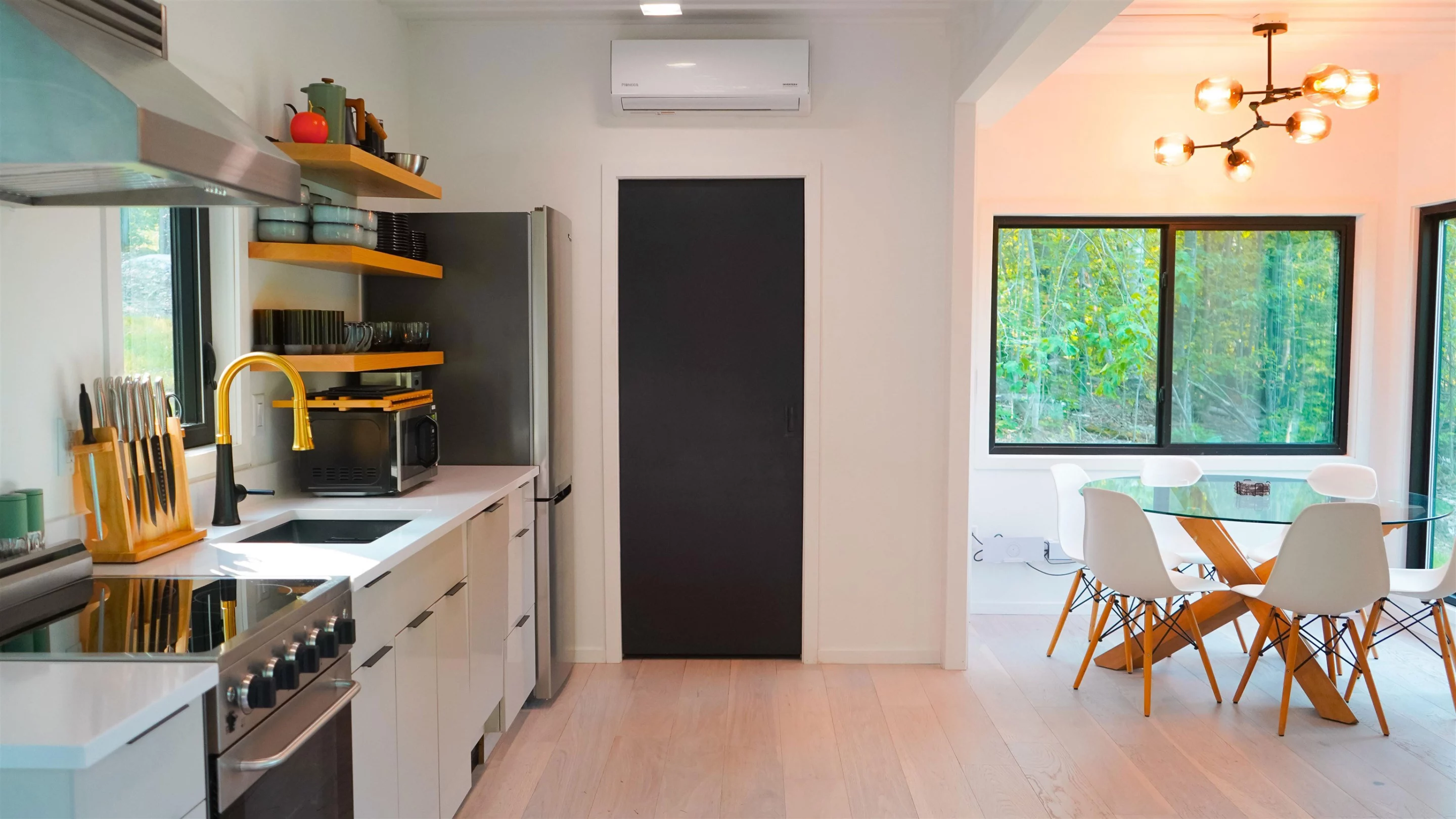 The Vermont Villa's kitchen includes an oven and cooktop, a full-size fridge/freezer, a sink, microwave, and a dining table for four
