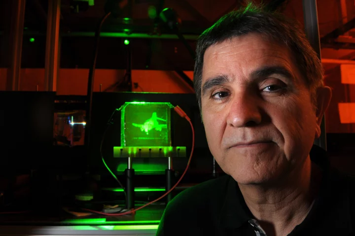 Project leader Nasser Peyghambarian with a refreshable, holographic image of an F-4 Phantom jet (Photo: University of Arizona)