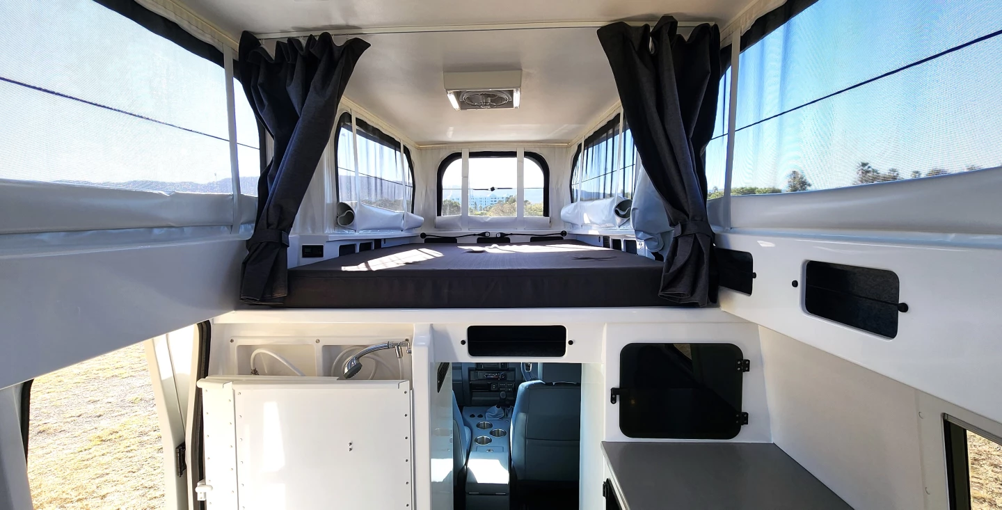 The EarthCruiser XTR6x6 sleeps three on a combination of its above-cab bed and convertible dinette