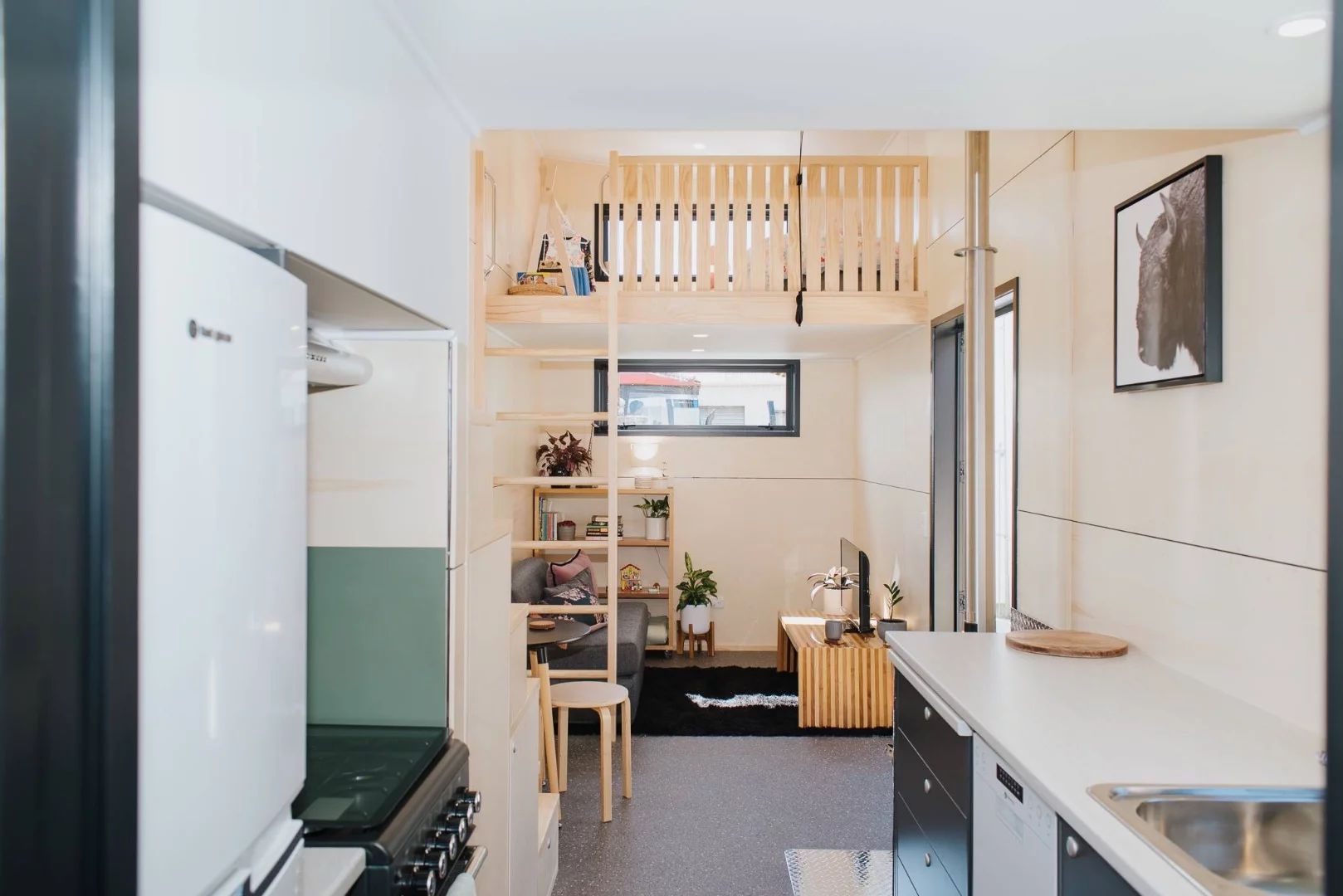 La Sombra Tiny House's downstairs includes a living room, small dining area, kitchen, and bathroom