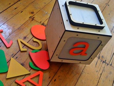 The cube-shaped Alphabot has infrared emitters at its corners so that the Playtime Computing system can track its movement within the play area and beyond