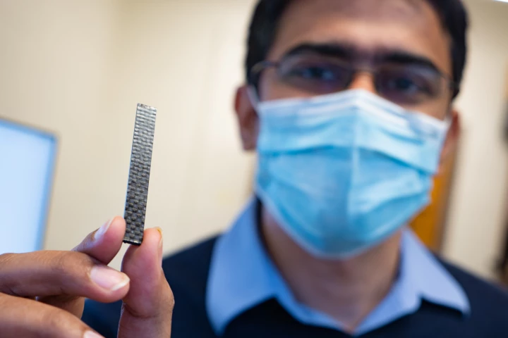 Asst. Prof. Aniruddh Vashisth displays a sample of the carbon fiber reinforced vitrimer material