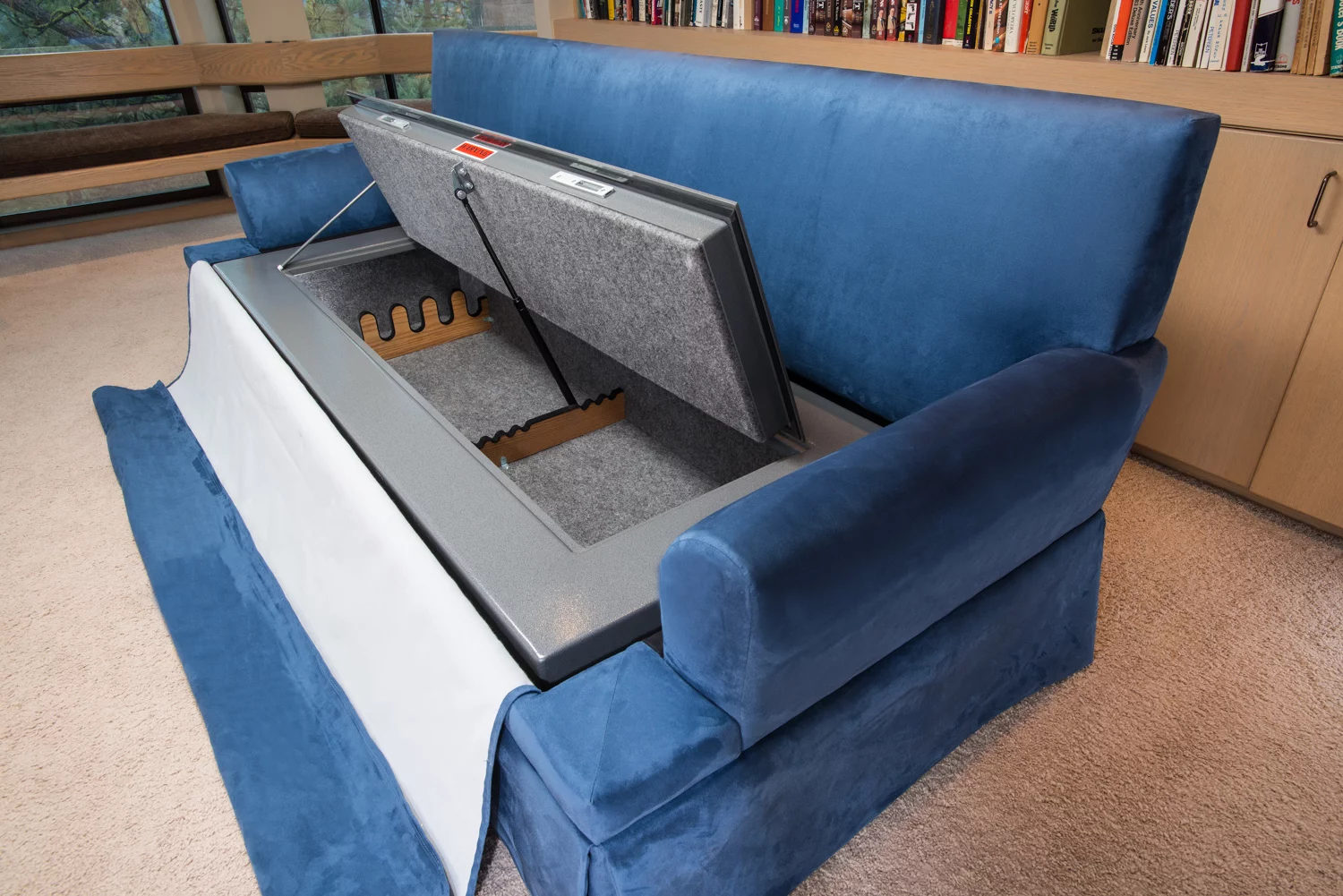 Besides offering a comfy place to sit and watch TV, the CouchBunker conceals a large gun safe and provides some handheld shields in the form of bullet-resistant cushions
