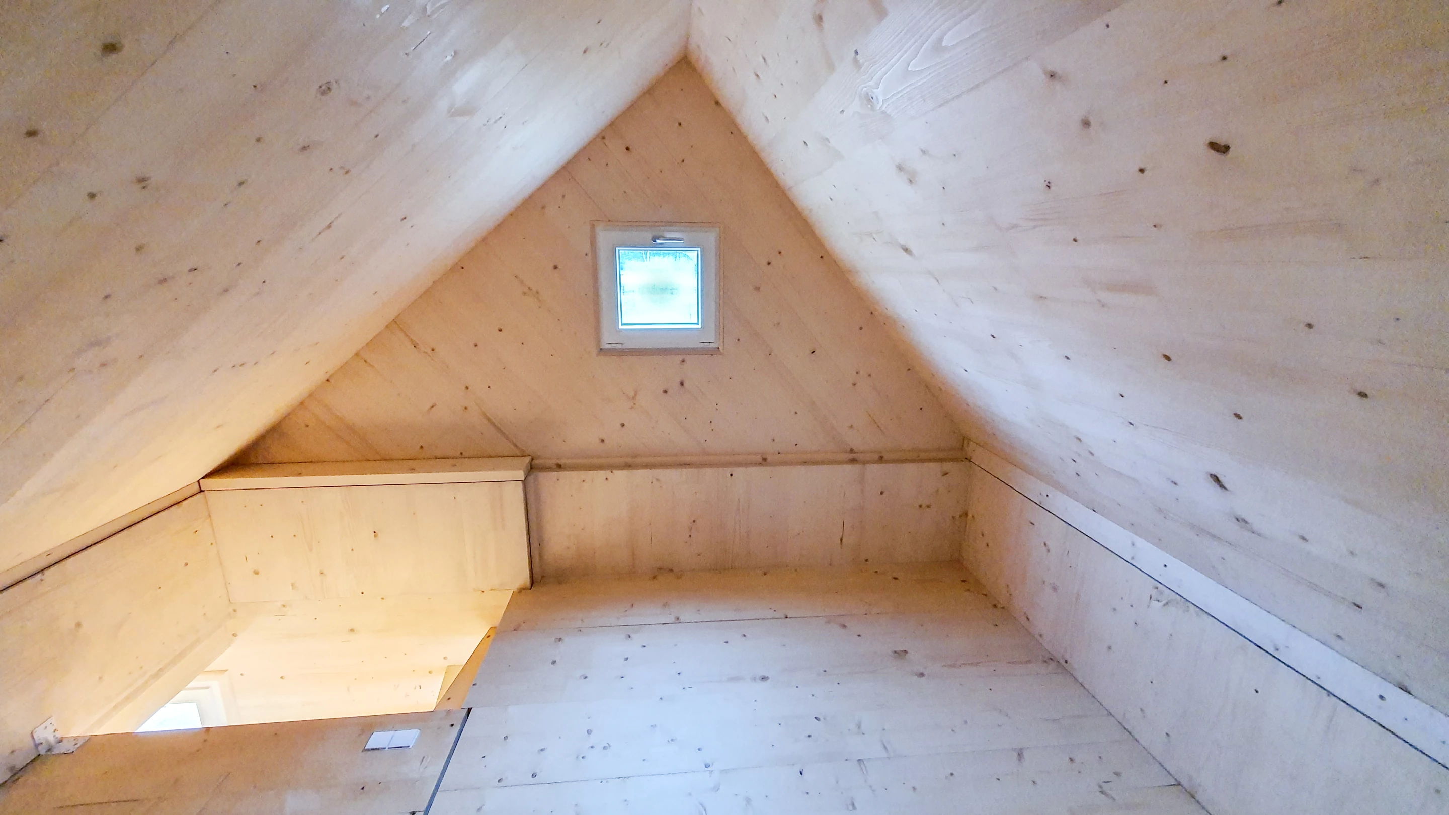 The Brette Haus features a standard tiny house loft-style bedroom accessed by steps