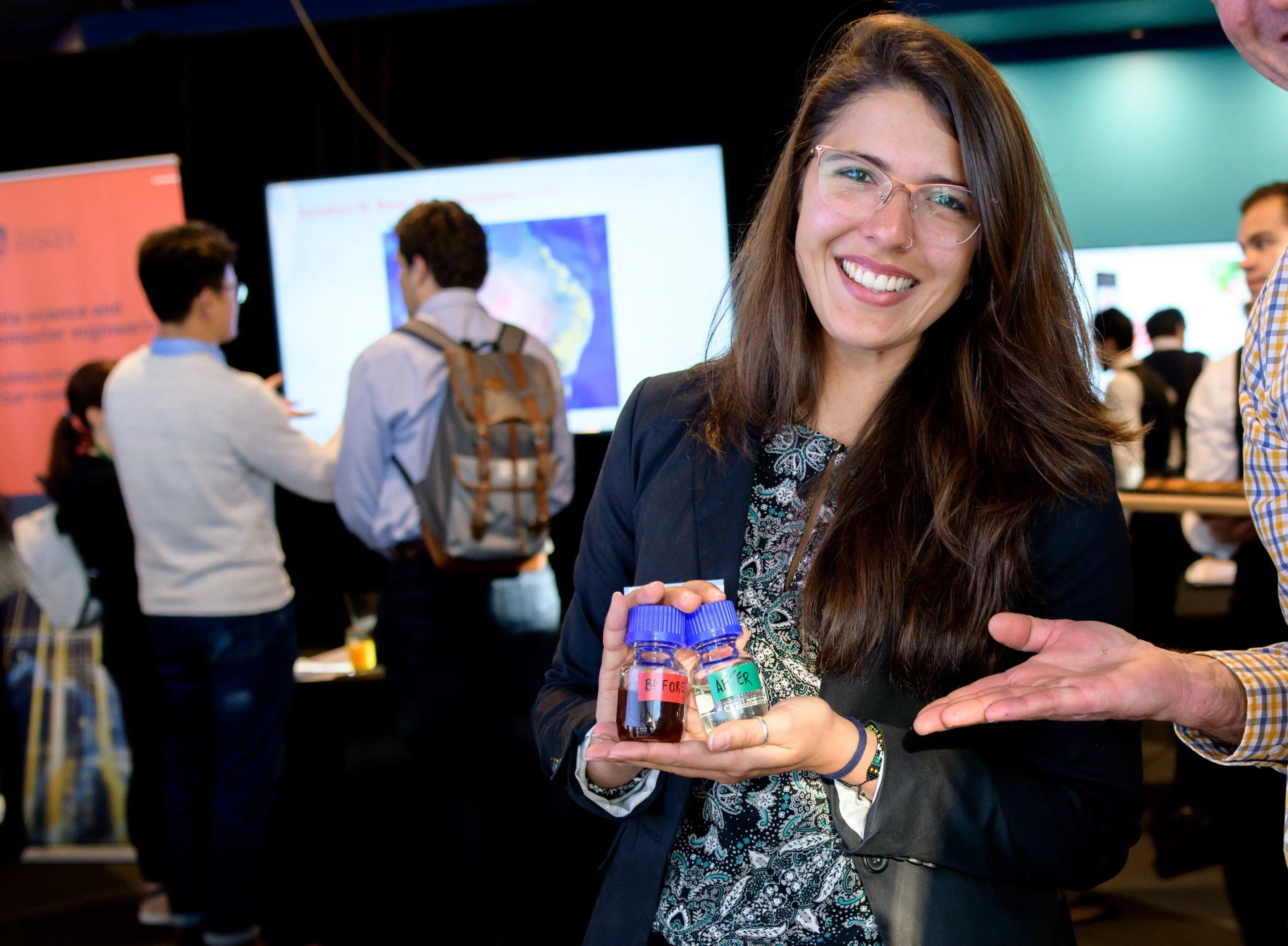 Lead researcher Julia Ciarlini Jungers Soares holds "Before and After" samples of the wastewater